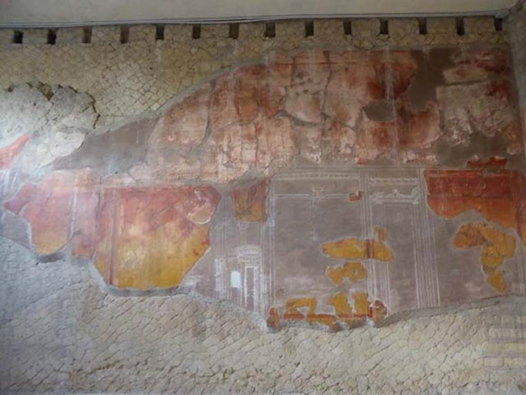 V.8, Herculaneum. October 2014. Room 7, detail from west wall. Photo courtesy of Michael Binns. The middle areas of the walls were painted with a yellow background, this was then reddened by the heat of the volcanic surges.